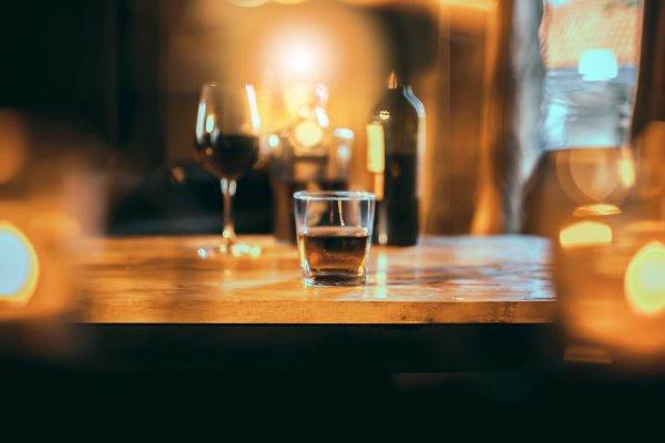 a glass of whiskey on wood bar